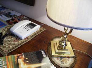 einen Tisch mit einer Lampe, einem Telefon und einem Buch in der Unterkunft B&B Santa Chiara in Sulmona