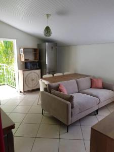 un salon avec un canapé et une table dans l'établissement Appartement spacieux à Le Lamentin, 95 m², vue mer, à Morne Vert