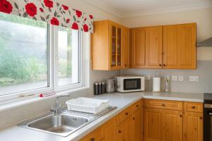 une cuisine avec un évier et une fenêtre dans l'établissement 3 Bed Bungalow - Sleeps 6 - Pet Friendly - Parking, à Drummore