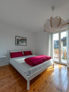 a bedroom with a large white bed with red pillows at Symphony Home in Pergine Valsugana