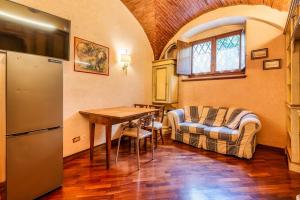 a kitchen with a table and a refrigerator in a room at Affreschi and Vintage Charm in Bergamo