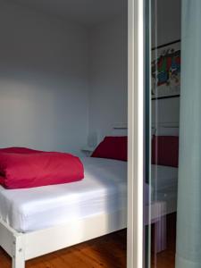 a bedroom with a white bed with a red blanket at Symphony Home in Pergine Valsugana
