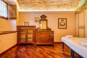 a bedroom with a bed and a dresser with a mirror at Affreschi and Vintage Charm in Bergamo +7 photos