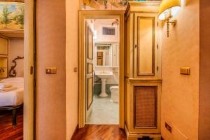 a hallway to a bathroom with a toilet and a sink at Affreschi and Vintage Charm in Bergamo