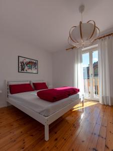 a bedroom with a large white bed with red pillows at Symphony Home in Pergine Valsugana +42 photos