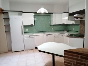 une cuisine avec des armoires blanches et une table à l'intérieur dans l'établissement Un Noël paisible, entre douceur,magie et surprise !, à Castelnau-de-Montratier 10 autres photos