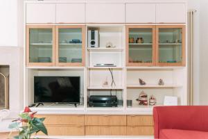 a large white cabinet with a television in it at Palladio Apartment - Vista Fiume, In Centro con Garage in Vicenza