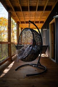 a man laying in a swing on a porch at Memories at Hillside A Modern Cabin Hocking Hills in McArthur