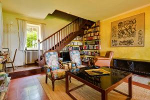 a living room with a table and chairs and a staircase at Casa Capitani by VacaVilla in Bardolino