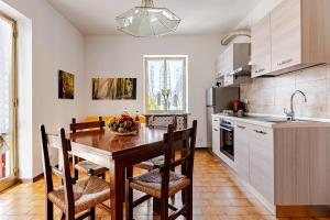 a kitchen with a wooden table with chairs and a sink at Ca’ Ruset in Roccaforte Mondovì