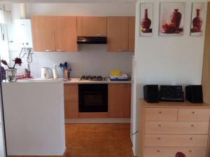 a kitchen with wooden cabinets and a stove top oven at Casita Ramona in Valencia
