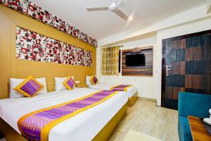 a bedroom with two beds and a tv at Hotel The White Sand Suites in New Delhi +17 photos