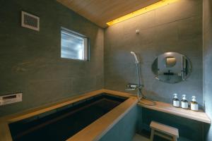 a bathroom with a bath tub and a mirror at 帰々Kiki in Yamatokoriyama +34 photos