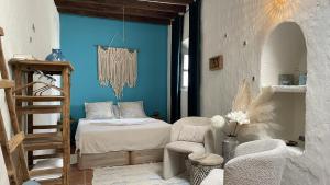 - une chambre avec un lit, une chaise et une échelle dans l'établissement Cuevas Soluna en Solara, voor max 8 personen, à Níjar