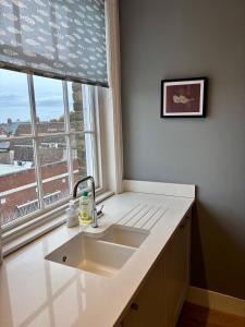 a kitchen counter with a sink and a window at Aspen-free parking-Grade II listed-second floor two bedrooms apartment in Huntingdon