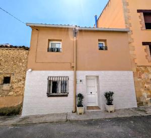 a building with two potted plants in front of it at Ca Amparo in Fuentes