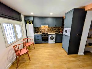 a kitchen with blue cabinets and a table and chairs at Ca Amparo in Fuentes