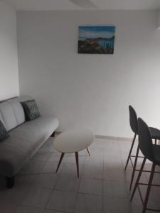 una sala de estar con un sofá, una mesa y sillas en Les Palmiers, en Trois-Rivières