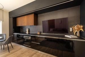 a kitchen with a table with a large tv on the wall at Charming & Luxurious Suite Garibaldi BIG - Fully equipped & renovated - Old Town in Olbia +59 photos