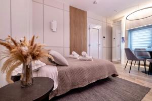 a bedroom with a bed and a table with a vase at Charming & Luxurious Suite Garibaldi BIG - Fully equipped & renovated - Old Town in Olbia