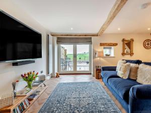 a living room with a blue couch and a flat screen tv at 1 Bed in Scaleby 94538 in Scaleby