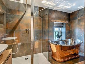 a bathroom with a copper tub in a shower at 1 Bed in Scaleby 94538 in Scaleby +19 photos