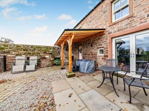 a patio with a grill and a brick building at 1 Bed in Scaleby 94538 in Scaleby