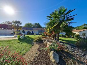 a yard with a palm tree and a house at La Galerne in Neuville-de-Poitou