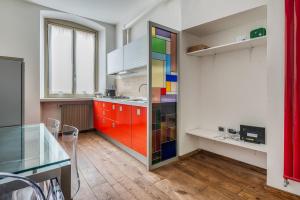 a kitchen with colorful cabinets and a glass door at Città alta Apartment-comfort in Bergamo