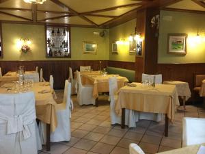 a dining room with white tables and white chairs at Albergo Ciori in Asiago