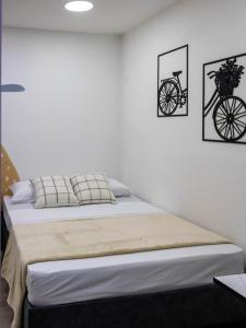 a bed in a bedroom with two pictures on the wall at S23 I City Lodge in Sabaneta