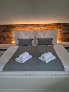 Una cama blanca grande con dos toallas encima. en Apartmán By One, en Banská Štiavnica