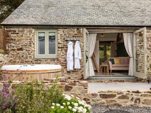 a stone house with a bath tub in the yard at 1 Bed in Combe Martin 75476 in Kentisbury