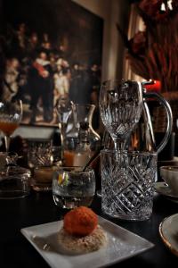 une table avec une assiette de nourriture et des verres à vin dans l'établissement Casa della Nonna, à Diest