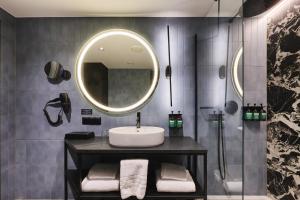 a bathroom with a sink and a mirror at voco Katowice by IHG in Katowice +136 photos