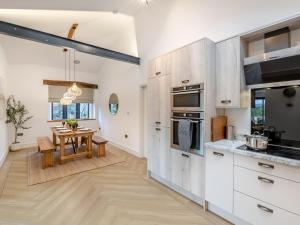 een keuken met witte kasten en een houten tafel bij 3 Bed in Great Ayton 95777 in Great Ayton