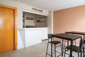 a room with a table and chairs and a kitchen at Limehome Benidorm Calle Mayor in Benidorm