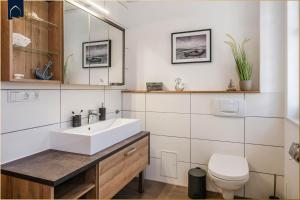 a bathroom with a sink and a toilet at 257 Haus Otto in Ahlbeck +32 photos