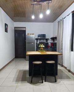 une cuisine avec un îlot avec deux tabourets dedans dans l'établissement Coral House Fortuna, à Tanque