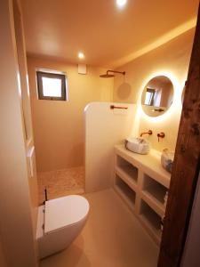 a bathroom with a white toilet and a sink at Mera Wellness B&B in America