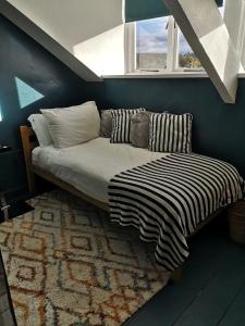 - une chambre avec un lit, un tapis et une fenêtre dans l'établissement Faith Cottage, à Brampton