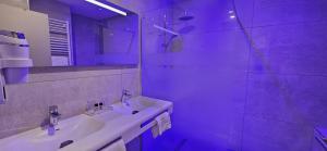 une salle de bain blanche avec un lavabo et une douche dans l'établissement Berg'hotel, à Socx