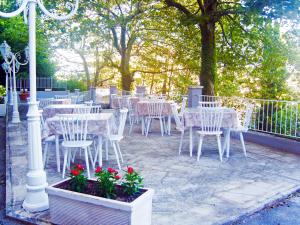 a group of white tables and chairs with red flowers at Hotel Panorama in Chianciano Terme