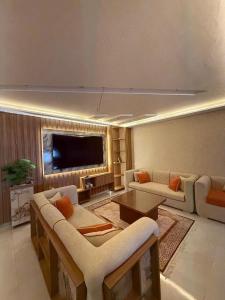 een woonkamer met banken en een flatscreen-tv bij Luxury Suite Haut FOunty Golden Stay in Agadir