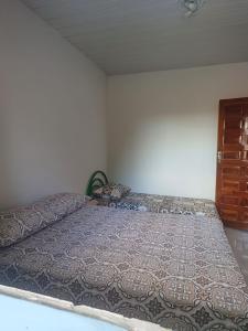 1 cama grande en un dormitorio con puerta de madera en Vila Velho Chico, en Bom Jesus da Lapa