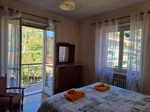 a bedroom with a bed with two orange towels on it at Casa Camelia in Torre Pellice