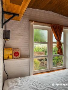 a bedroom with a bed and a window at Winterharde pipowagen met hottub, bbq & uitzicht in Luttelgeest