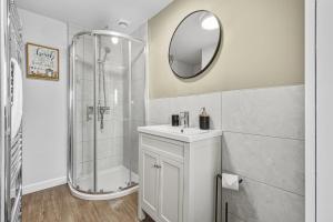 ein Badezimmer mit Dusche, Waschbecken und Spiegel in der Unterkunft 3-BR Luxe Cowes Cottage Harbour Views, Sleeps 6, with Private Garden - LONG TERM STAY SPECIAL OFFER AVAILABLE! - by Blue Puffin Stays in Isle of Wight + 34 Fotos