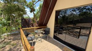 una porta aperta su un patio con tavolo e sedie di Chales da Kitanda Petit a Teresina