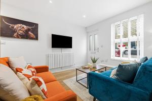 ein Wohnzimmer mit zwei Sofas und einem Fernseher in der Unterkunft 3-BR Luxe Cowes Cottage Harbour Views, Sleeps 6, with Private Garden - LONG TERM STAY SPECIAL OFFER AVAILABLE! - by Blue Puffin Stays in Isle of Wight